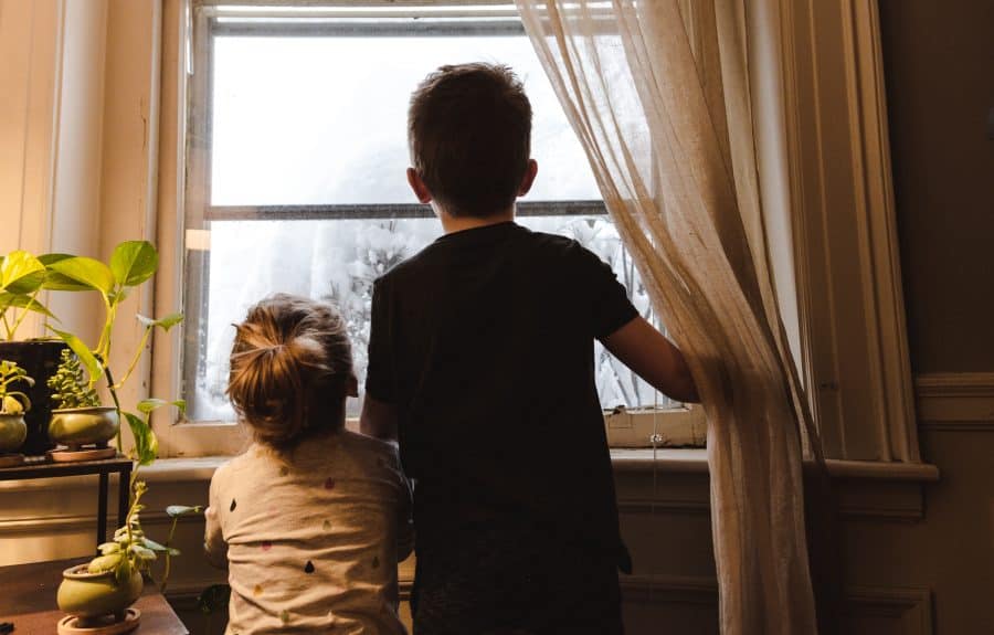 children-looking-out-of-the-window-at-their-home
