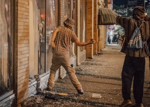 man-throwing-brick-through-window