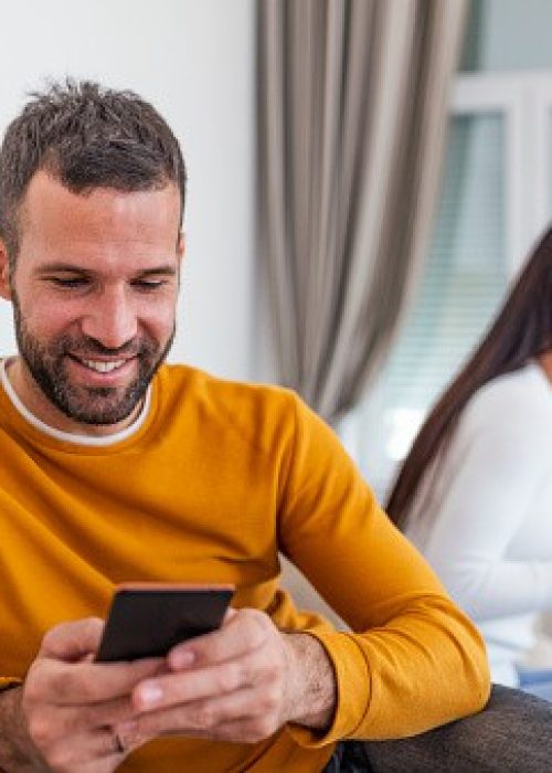 man-texting-his-girlfriend-with-wife-in-the-same-room